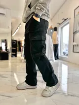 Pantalón cargo de jean negro, de corte ancho y holgado, con bolsillos laterales con solapa.