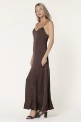 Vestido largo de satén color chocolate, con escote en V y tirantes finos. Presenta un corte fluido con un detalle de godet lateral en encaje a tono.