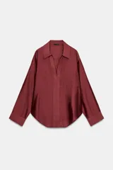 Camisa amplia de cuello solapa con escote en pico y manga larga, en tejido satinado de color bordó. Cuenta con un bolsillo de plastrón en el frente y un diseño holgado.