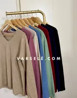 Sweater de punto color bordó con escote en V y detalle de strass aplicado en la parte frontal. Presenta mangas largas y corte holgado.