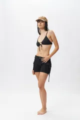 Top de bikini blanco con escote halter, abertura circular en el centro y lazos ajustables.