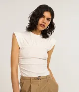 Blusa de algodón color blanco, con cuello redondo, mangas cortas con hombreras estructuradas y cuerpo con frunces texturizados en todo su largo.