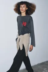 Camiseta de manga larga, corte regular, color negro con efecto lavado o acid wash. Presenta un estampado frontal en rojo con la palabra "LOVE" estilizada.