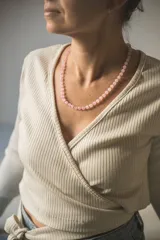 Collar de cuentas de cuarzo rosa de 6mm de diámetro, con separadores de hilo rosado y cierre de mosquetón de acero hipoalergénico con baño dorado.