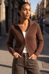Campera de punto de algodón color marrón, con diseño acanalado, cuello alto tipo polo y cierre frontal completo con doble deslizador. Cuenta con mangas largas y calce al cuerpo.