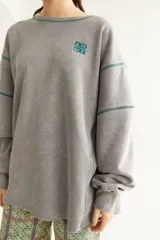 Buzo de algodón marrón con efecto acid wash, cuello redondo, mangas largas y forro interno de polar. Cuenta con costuras decorativas y bordado azul en el pecho.