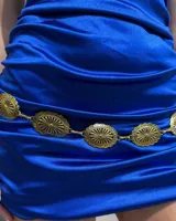 Cinturón de cadena metálica dorada compuesto por eslabones circulares con diseño grabado en relieve.