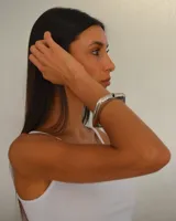 Brazalete rígido plateado con cierre a presión. Diseño minimalista y moderno.