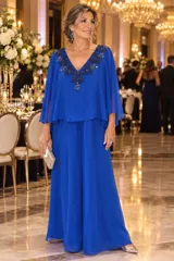 Vestido largo de gasa color azul, con diseño de líneas simples y sobrecapa superior con detalle de bordado al tono en el escote en V.