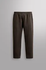 Pantalón jogger de corte relajado confeccionado en tejido compacto de algodón. Presenta cintura elástica con cordón interior, bolsillos frontales en la cadera y un bolsillo trasero de plastrón.