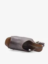 Sandalias de cuero negro con cuña alta de madera y plataforma delantera, detalle de tachas metálicas en los laterales y tira con hebilla en el talón.