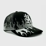 Gorra tipo trucker negra con panel frontal bordado con el logo "LA" en blanco y llamas grises. La visera también presenta bordados de llamas en blanco y gris. La parte trasera es de malla negra y cuenta con cierre ajustable.