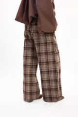 Pantalón tipo balloon de tejido plano con calce relajado, cintura elastizada y estampado cuadrillé en tonos marrones y beige.