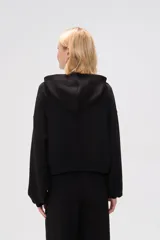 Canguro negro con capucha y mangas largas abullonadas.