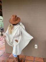 Capa color crema de tejido fino en lana merino con detalles en cuero.