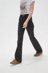 Pantalon de jean azul con corte flare y tiro alto, con cierre frontal y bolsillos.