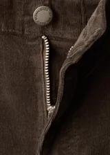 Pantalón de pana estilo flare con tiro medio, cierre de botón y cremallera, trabillas para cinturón y diseño de cinco bolsillos.