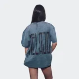 Remera de corte oversize con efecto de lavado ácido en color azul, presenta un estampado pequeño en el centro del pecho con la palabra Relajo.