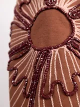 Buzo de algodón color negro con cuello redondo, mangas largas y bordado floral XL en color cobre en las mangas. Presenta un diseño holgado y cómodo.