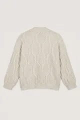 Saco abierto de punto con diseño de trenzas, color beige, con bolsillos frontales y detalle de lentejuelas integradas en el tejido.