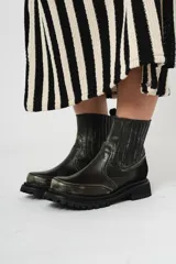 Botas de cuero negro con elásticos laterales, detalle de gamuza en el talón y suela de goma con plataforma.