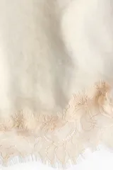 Vestido corto de satén color beige con breteles spaghetti ajustables, escote recto y detalles de encaje en el escote y el bajo.