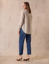 Blusa color beige de lino, marca Dash. Cuello a la base, escote en V y abertura con botones. Delantera con bolsillos. Largo de manga regulable con presilla y botón.