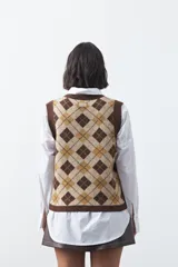 Chaleco tejido sin mangas con diseño de rombos tipo argyle en tonos marrón y beige, con cuello redondo y terminaciones acanaladas.