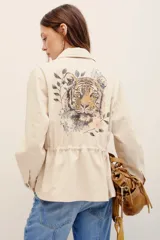 Campera estilo militar color beige, con cierre frontal y bolsillos aplicados en el pecho.