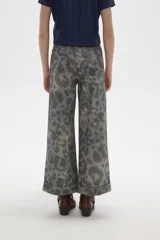Pantalon de jean de corte ancho y tiro alto, con diseño estampado animal print en tonos grisáceos. Presenta pinzas en la cintura y ruedo con doblez.