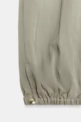 Pantalón bombacho de tiro medio color vino, con cintura ajustable mediante cordón y puños elásticos ajustables con botón en los tobillos.