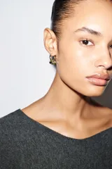 Pack de cuatro pendientes tipo aro. Dos son aros lisos dorados con cierre de clip. Los otros dos son aros dorados con un dije colgante esférico bicolor (dorado y plateado) con cierre de clip.