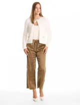 Chaqueta corta de tejido tipo mohair en color blanco, con cuello a la base decorado con bordado de perlas y canutillos. Presenta bolsillos simulados en el frente con apliques de brillos y cierre mediante broche interno.