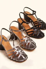 Sandalia de cuero negro con tiras cruzadas en el empeine, diseño en T con tira ajustable al tobillo y taco cuadrado.