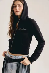 Campera crop tipo hoodie color negro, con capucha, cierre frontal metálico y bolsillos canguro. Presenta diseño corto y bordado sutil de la marca en el pecho.