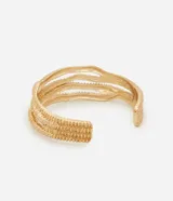Pulsera rígida de diseño abierto con textura grabada y acabado en tono dorado. Presenta un estilo moderno y minimalista, ideal para complementar diversos looks.