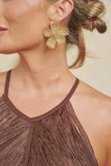 Caravanas doradas con forma de flor, adornadas con pedrería brillante.