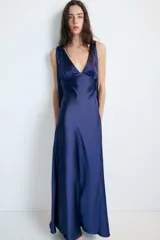 Vestido midi satinado color marrón, con escote en V y tirantes anchos ajustables con lazada en los hombros. Presenta cierre lateral con cremallera oculta.