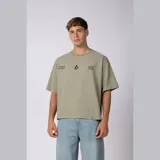 Remera boxy de calce corto y ancho, color verde oliva, con cuello redondo, mangas cortas y estampa frontal minimalista con texto y logo.