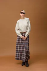 Sweater de punto fino color beige, con cuello redondo, mangas largas y diseño corto con terminación acanalada en la cintura.