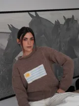 Sweater tejido a mano de color azul marino con diseño de la bandera de Uruguay en el centro del frente. Presenta un calce relajado, cuello redondo y terminaciones simples en puños y dobladillo.