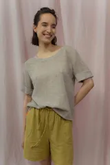 Short blanco de calce relajado con cintura elástica y lazo regulable. Presenta bolsillos amplios con ribete interior de color naranja neón.