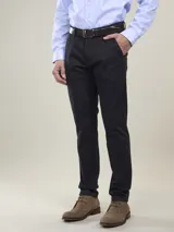 Pantalón de vestir azul marino, de corte recto, con bolsillos laterales y traseros. Se ajusta a la cintura con cinturón de cuero marrón.