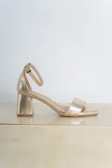 Sandalias doradas de cuero vegano, con taco cuadrado de 6 cm y pulsera al tobillo con hebilla.