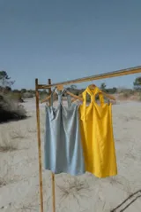 Vestido corto de calce relajado con escote halter y detalle de nudo en el cuello. Confeccionado en tela liviana, presenta un diseño fluido y espalda con elástico para un ajuste adaptable.