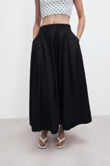 Falda midi de tiro alto en color verde militar, con diseño acampanado y cintura elástica. Presenta costuras verticales que definen su estructura y cierre lateral con cremallera oculta.