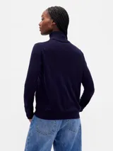 Buzo de punto con cuello alto tipo polera, de corte ajustado y manga larga.