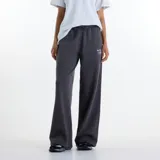 Pantalón de jogging New Balance modelo Trackside, color gris oscuro, de corte holgado y pernera ancha. Confeccionado en felpa francesa suave, cuenta con cintura elástica ajustable con cordón y un pequeño estampado y bordado en la pierna izquierda.