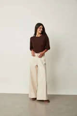 Jean azul oscuro de corte wide leg y tiro alto, con costuras pespunteadas verticales al frente y cinturón incorporado con hebilla cuadrada.