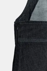 Vestido midi de denim color azul oscuro, confeccionado con mezcla de algodón. Presenta escote cuadrado, tirantes anchos, bolsillos delanteros de parche y falda de corte evasé.